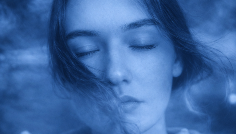 Eine schlafende Person mit einem hypnotischen, spiralförmigen Hintergrund.