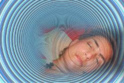 Eine schlafende Frau mit einem hypnotischen, kreisförmigen Muster um sie herum.